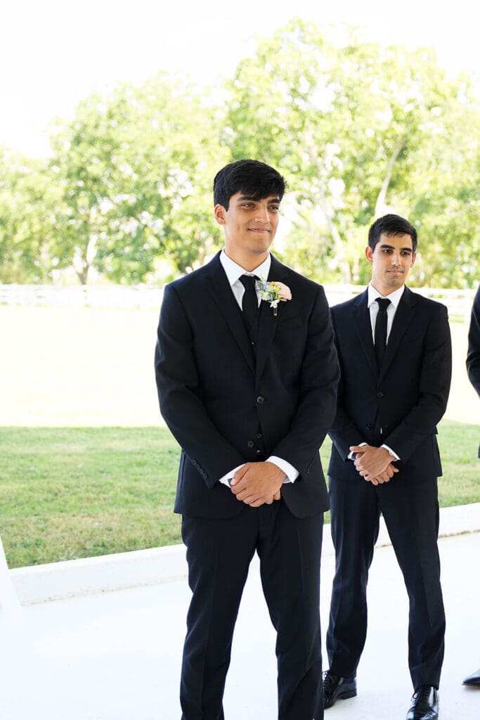 groom watching the bride walk down the aisle