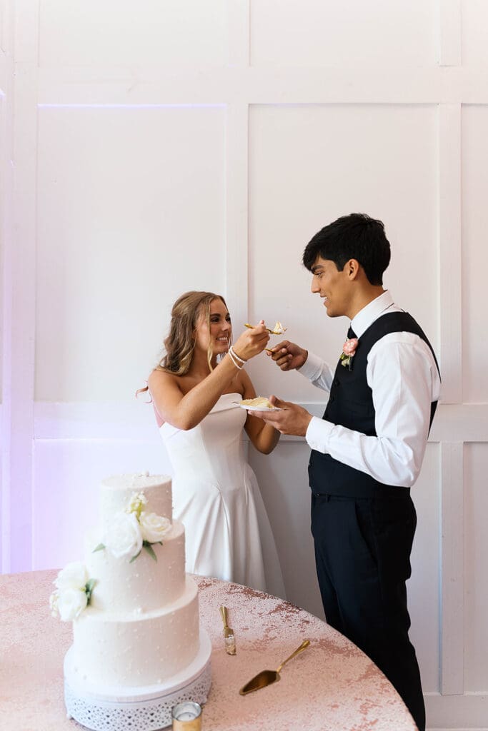 newly married couple trying their wedding cake