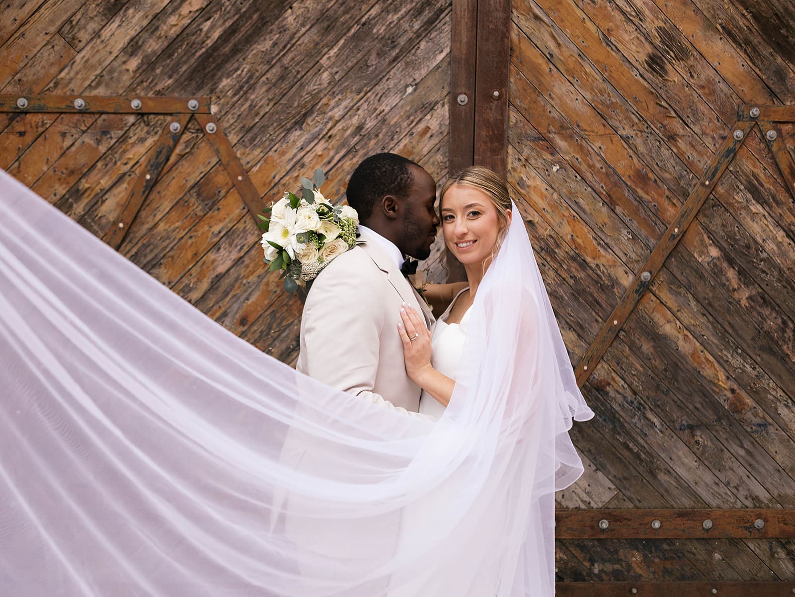 groom kissing the bride on the cheek